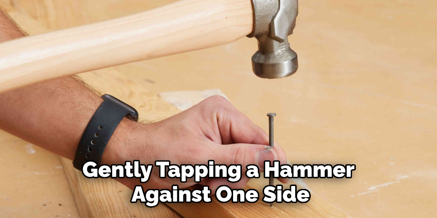 Gently Tapping a Hammer Against One Side